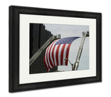 Framed Print, An Large American Flag Hanging Between Firefighter Truck Ladders - Essentials from JayCar